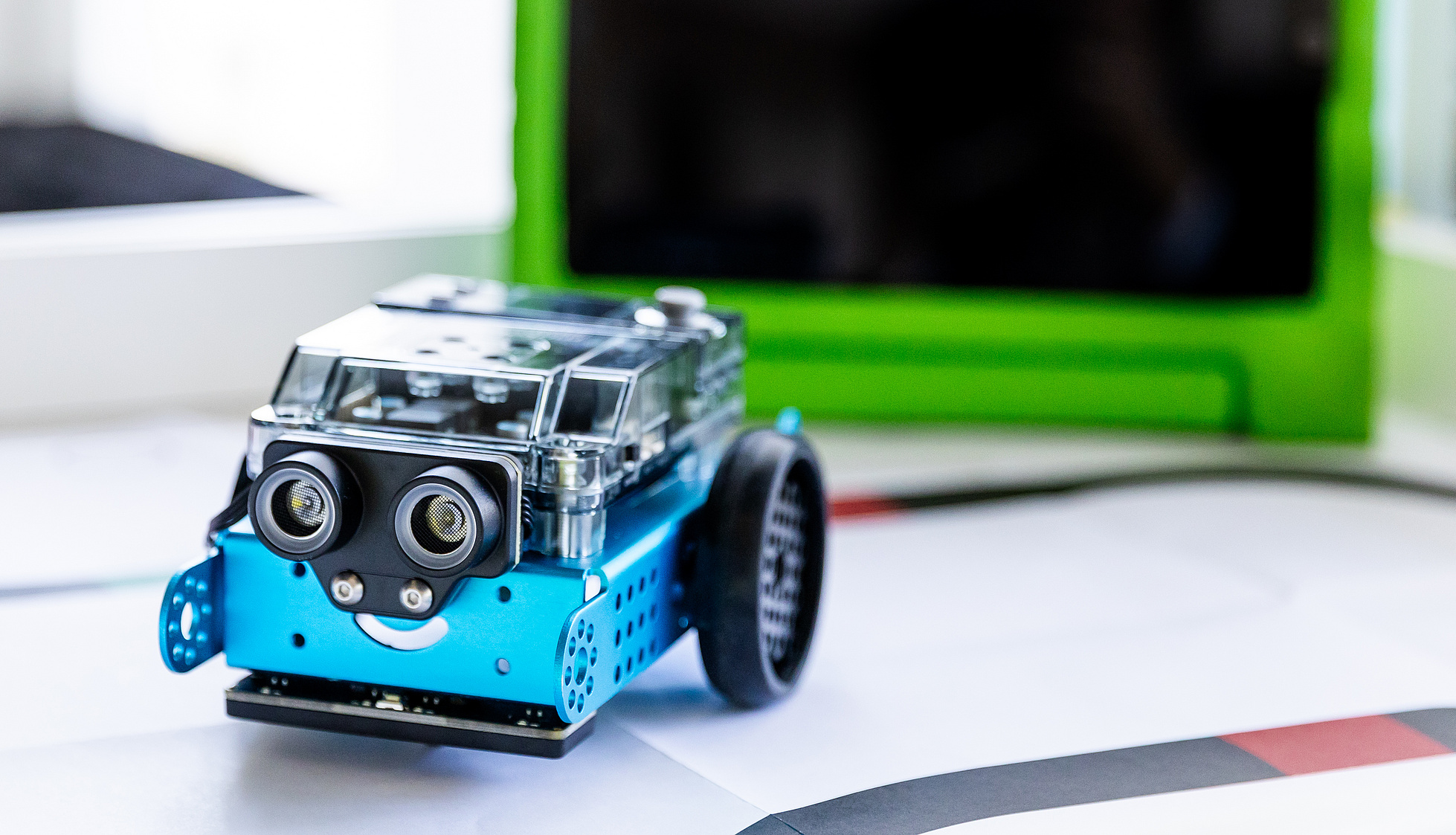 Ein Makeblock Education mBot 2 mit einem iPad auf einem Tisch stehend.