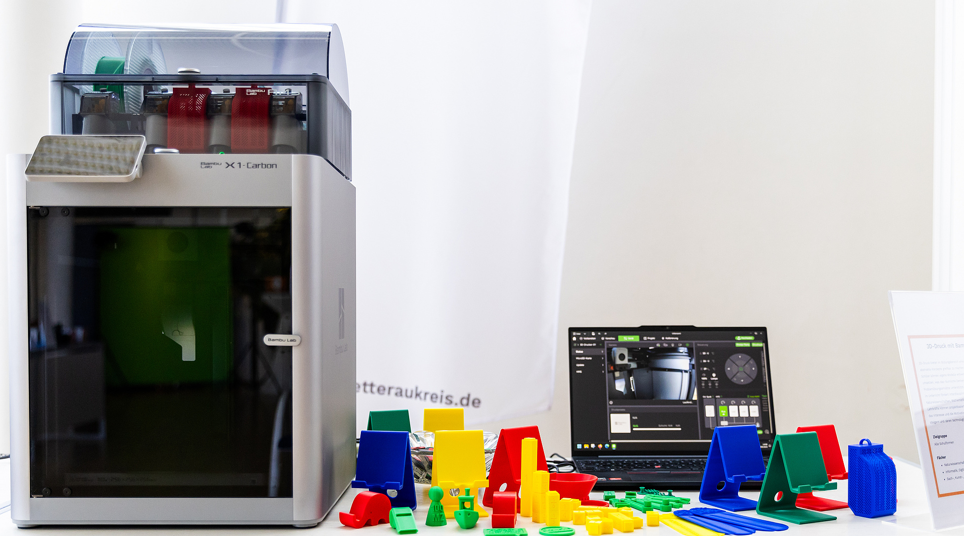 Ein 3D-Drucker von Bambi Lab mit bunten Exponaten.