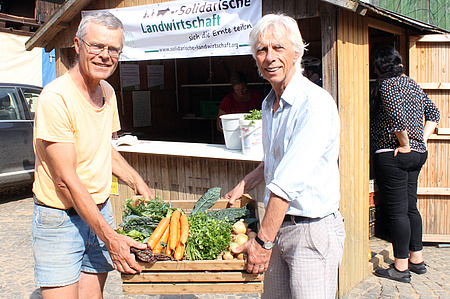 Gerrit Jansen und Dieter Fitsch tragen eine Gemüsekiste zur Abholstation