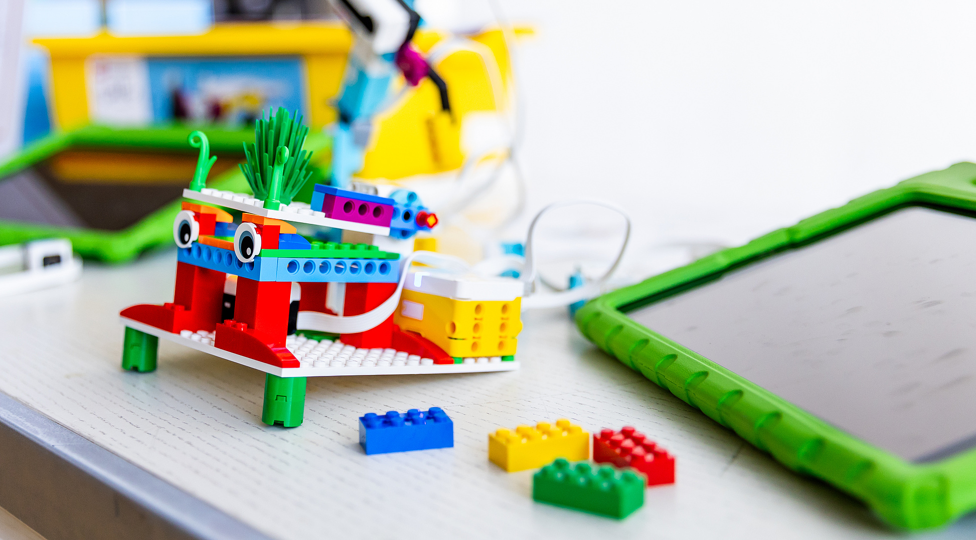 Auf dem Tisch befindet sich LEGO Education Spike Essential mit einem iPad.