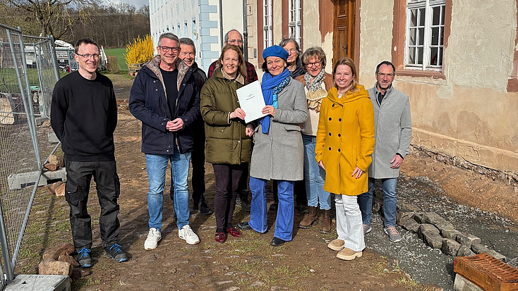 Eine Gruppe von Leuten vor einem alten Gebäude.