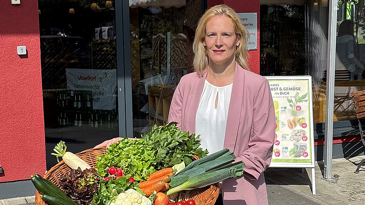 Birgit Weckler mit einem großen Korb voller Gemüse.