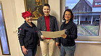 Marion Götz übergibt den Förderbescheid an Bereitschaftsleiterin Sina Dietz und Vereinsvorsitzende Christina Paulencu.