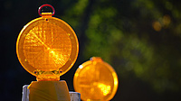 Zwei Baustellenwarnlampen stehen hintereinander