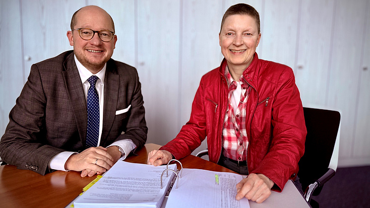 Rouven Kötter und Marion Götz sitzen an einem Tisch.